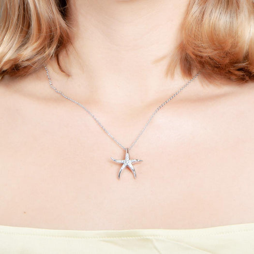 The picture shows a model wearing a 925 sterling silver starfish pendant with topaz.