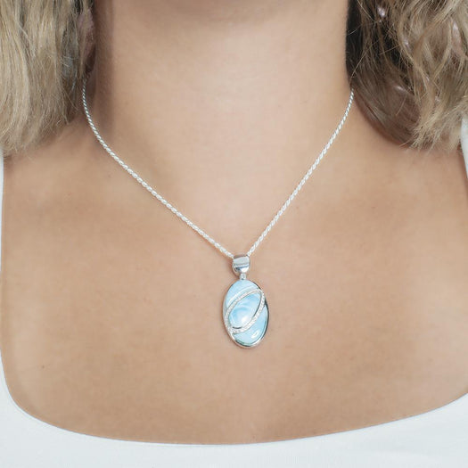 The picture shows a model wearing a 925 sterling silver larimar pendant with aquamarine and topaz.