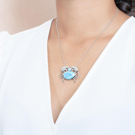 The picture shows a model wearing a 925 sterling silver larimar blue crab treasure pendant.