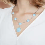 The picture shows a model wearing a 925 sterling silver larimar circle charm necklace.