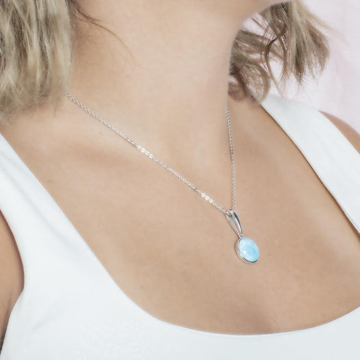 The picture shows a model wearing a 925 sterling silver larimar circle pendant.