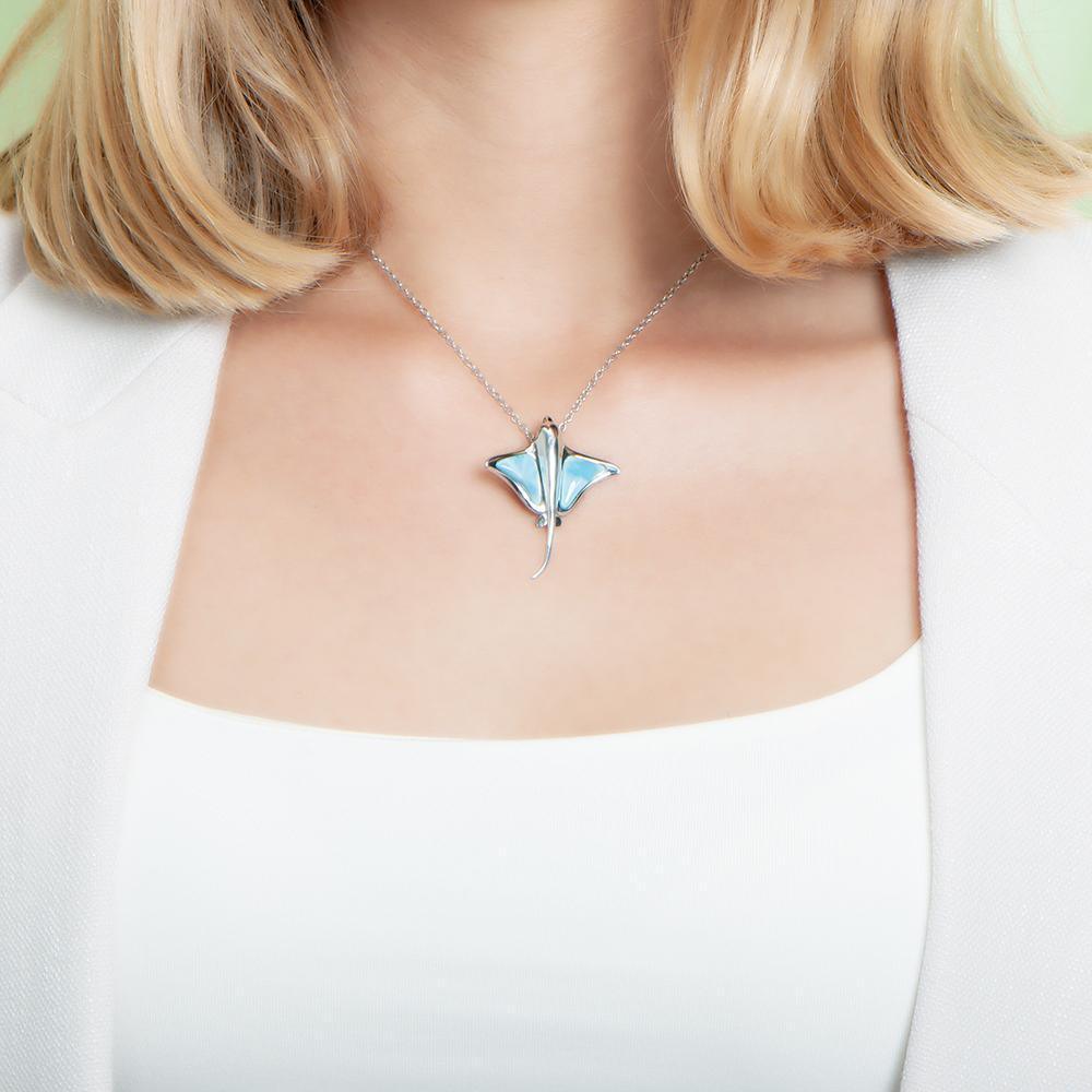 The picture shows a model wearing a 925 sterling silver larimar eagle ray pendant.