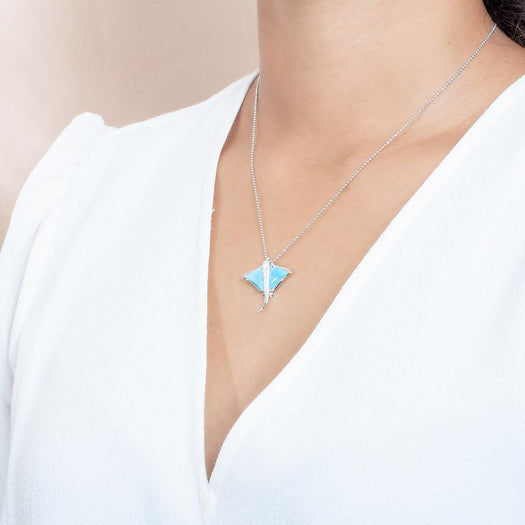 The picture shows a model wearing a 925 sterling silver larimar eagle ray pendant with cubic zirconia.