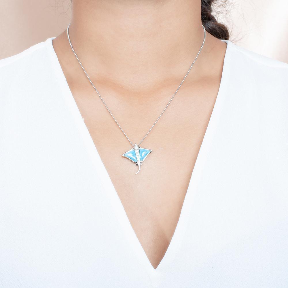 The picture shows a model wearing a 925 sterling silver larimar eagle ray pendant with cubic zirconia.