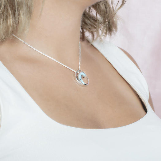 The picture shows a model wearing a 925 sterling silver larimar high tide pendant.