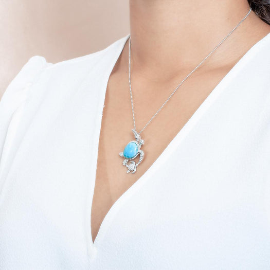 The picture shows a model wearing a 925 sterling silver larimar sea turtle pendant.