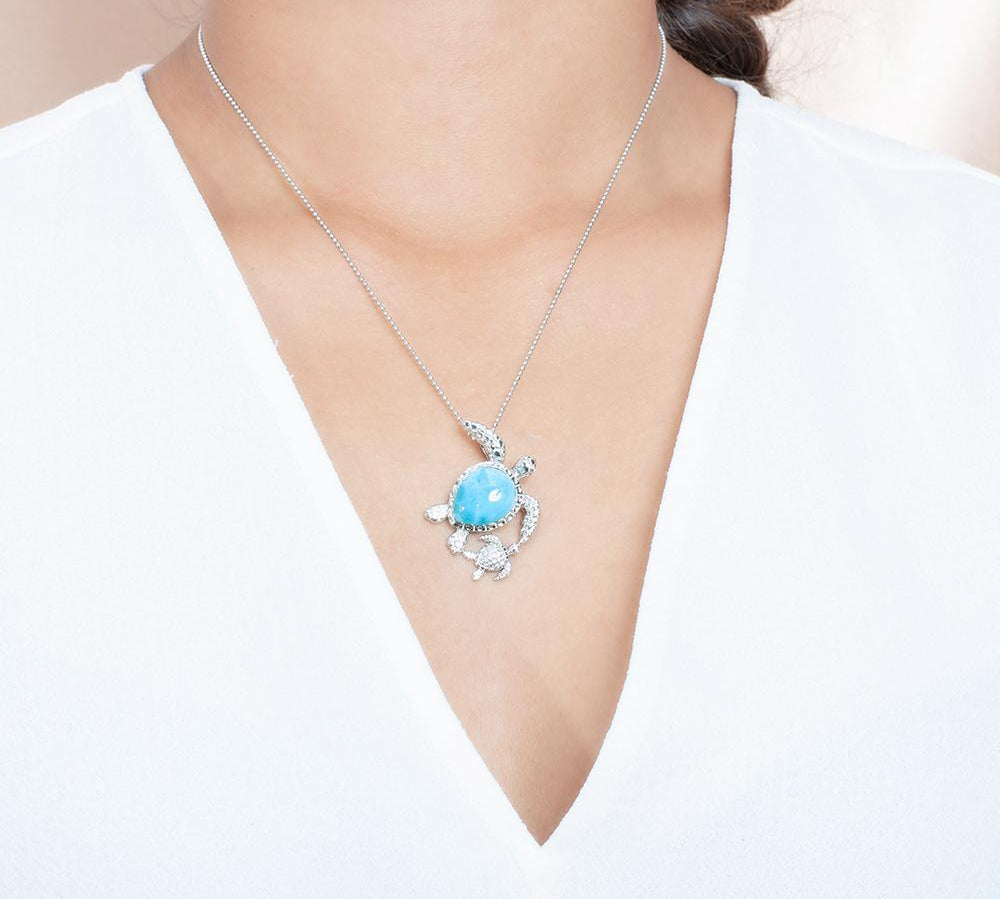 The picture shows a model wearing a 925 sterling silver larimar sea turtle pendant.