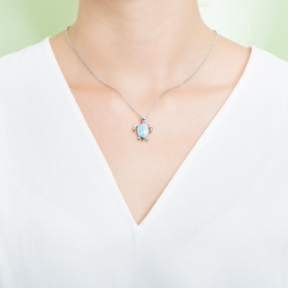 The picture shows a model wearing a 925 sterling silver larimar sea turtle pendant.