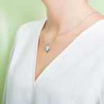 The picture shows a model wearing a 925 sterling silver larimar sea turtle pendant.