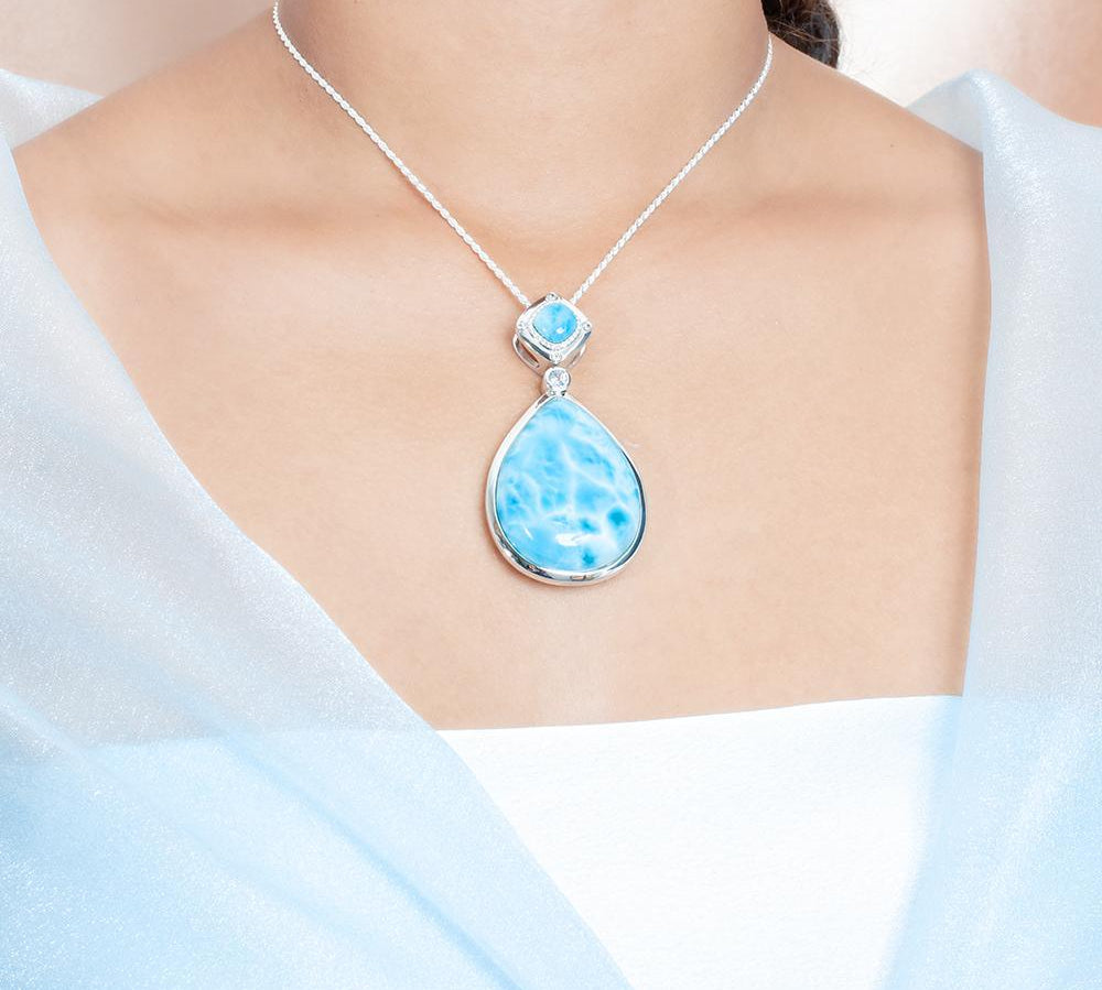 The picture shows a model wearing a 925 sterling silver larimar teardrop pendant.