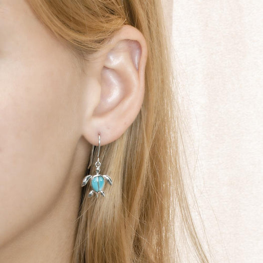 The picture shows a model wearing a 925 sterling silver larimar sea turtle hook earring.