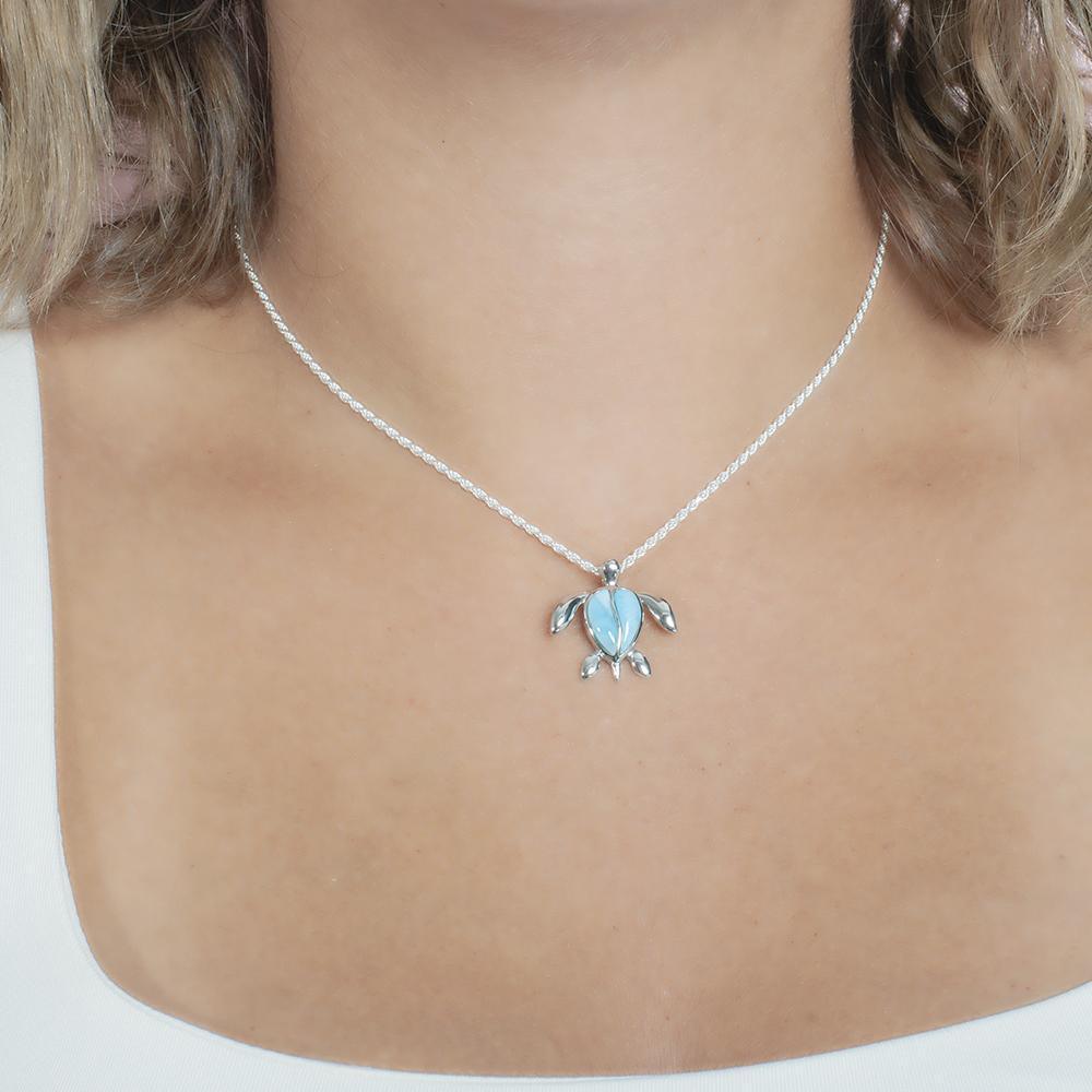 The picture shows a model wearing a 925 sterling silver larimar sea turtle pendant.