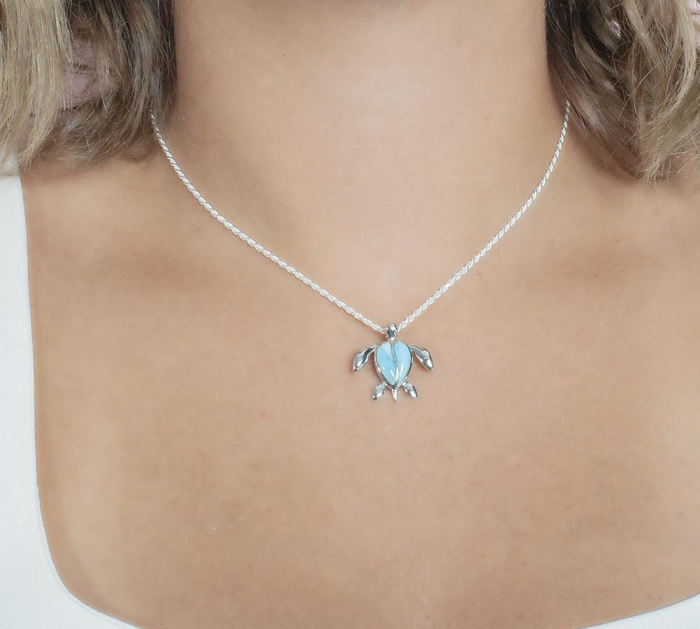 The picture shows a model wearing a 925 sterling silver larimar sea turtle pendant.