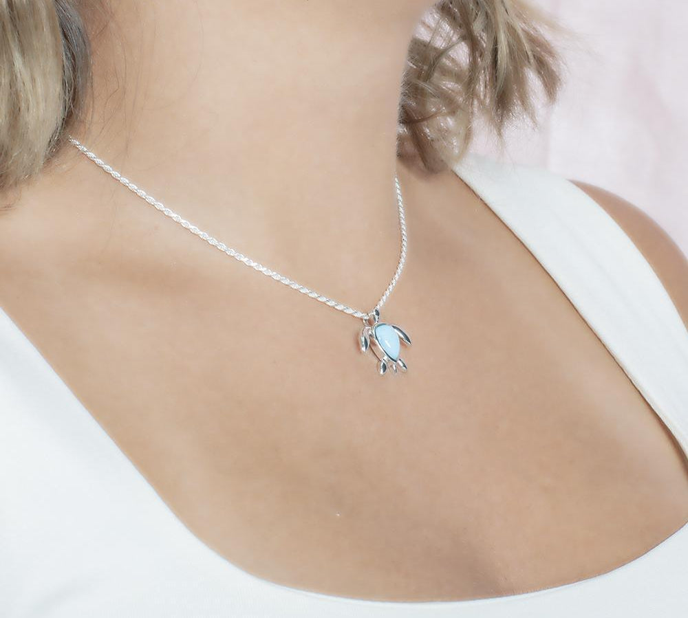 The picture shows a model wearing a 925 sterling silver larimar sea turtle pendant.