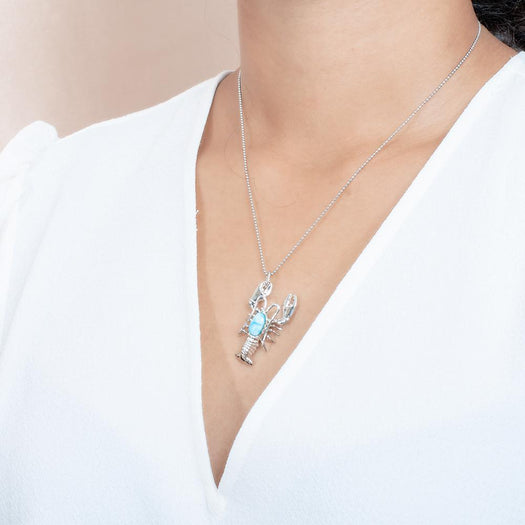 The picture shows a model wearing a 925 sterling silver larimar lobster pendant.