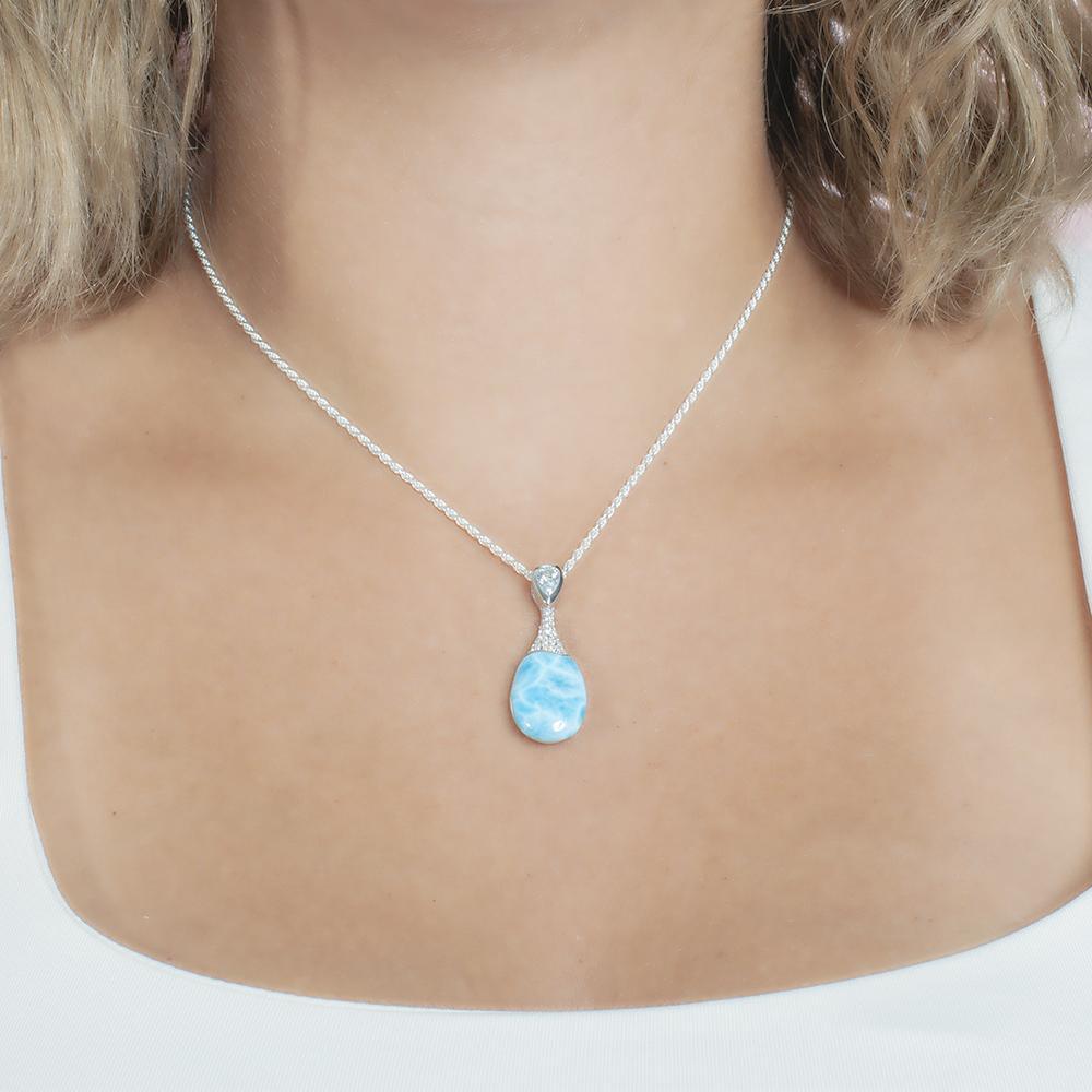 The picture shows a model wearing a 925 sterling silver larimar love potion bottle pendant with aquamarine and topaz.
