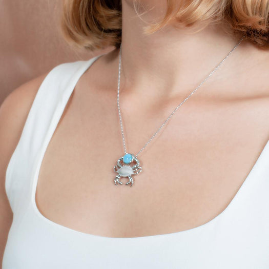 The picture shows a model wearing a 925 sterling silver larimar lucky blue crab pendant.