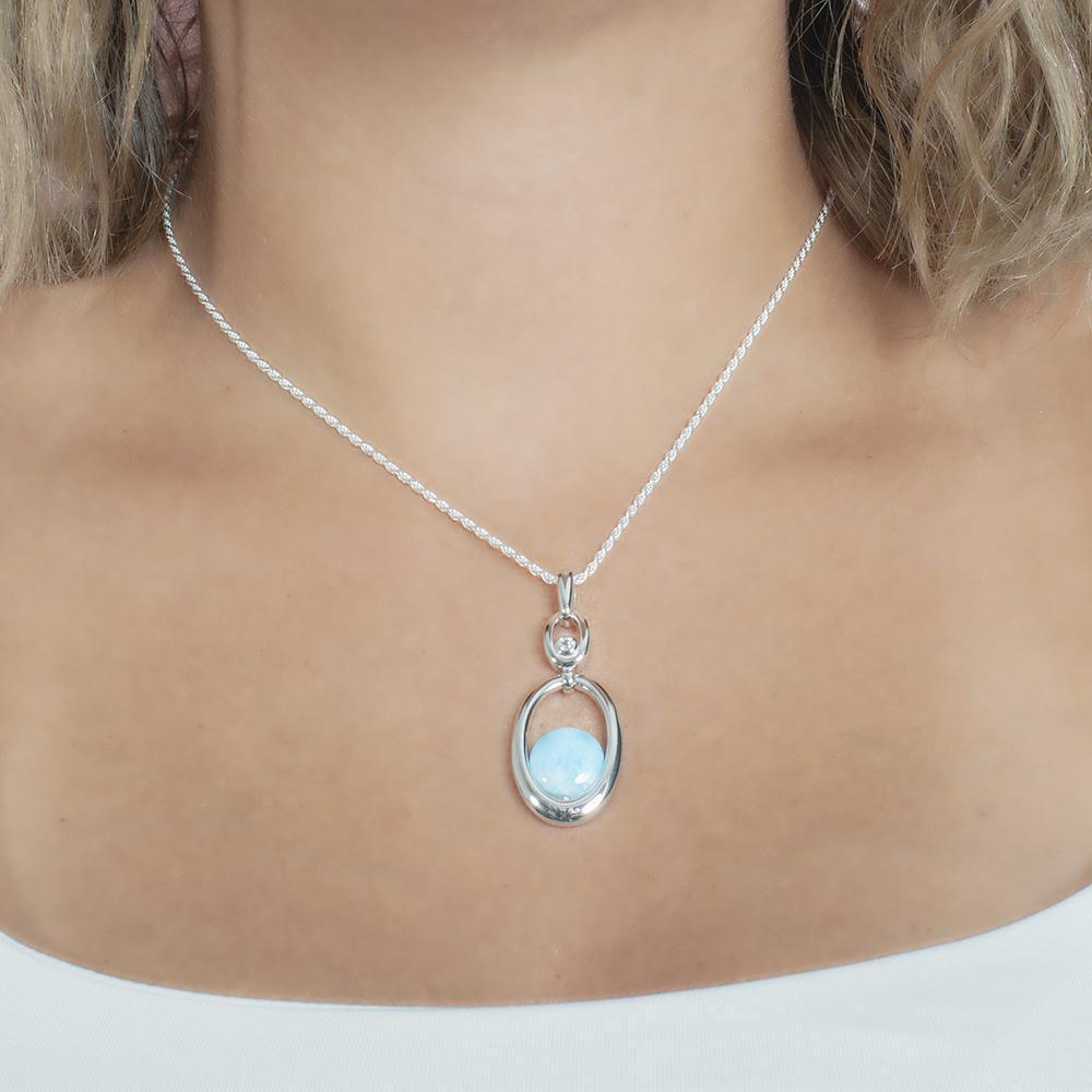 The picture shows a model wearing a 925 sterling silver larimar lunar eclipse pendant.