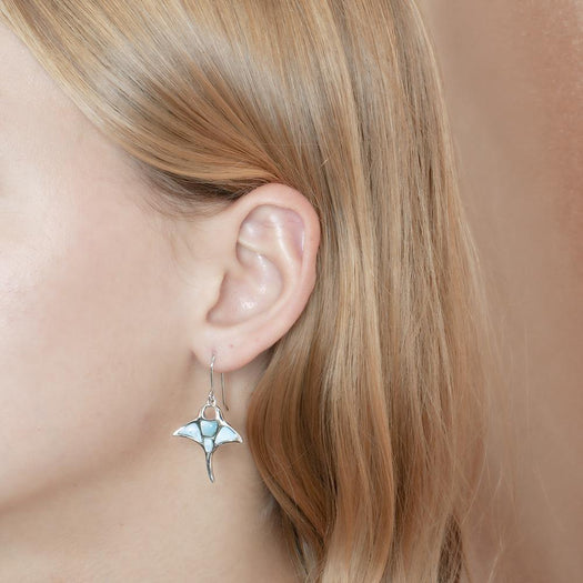 The picture shows a model wearing a 925 sterling silver larimar manta ray hook earring.