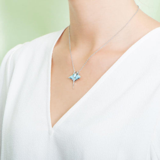 The picture shows a model wearing a 925 sterling silver larimar manta ray pendant.