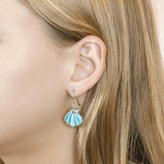 The picture shows a model wearing a 925 sterling silver larimar mermaid's oyster shell hook earring.