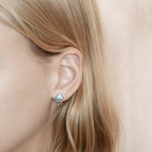 The picture shows a model wearing a 925 sterling silver larimar moon jellyfish stud earring.