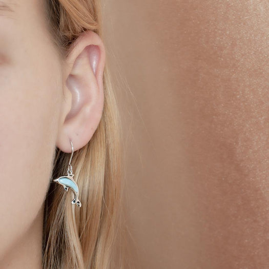 The picture shows a model wearing a 925 sterling silver larimar dolphin small hook earring.