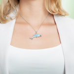 The picture shows a model wearing a 925 sterling silver larimar dolphin pendant.