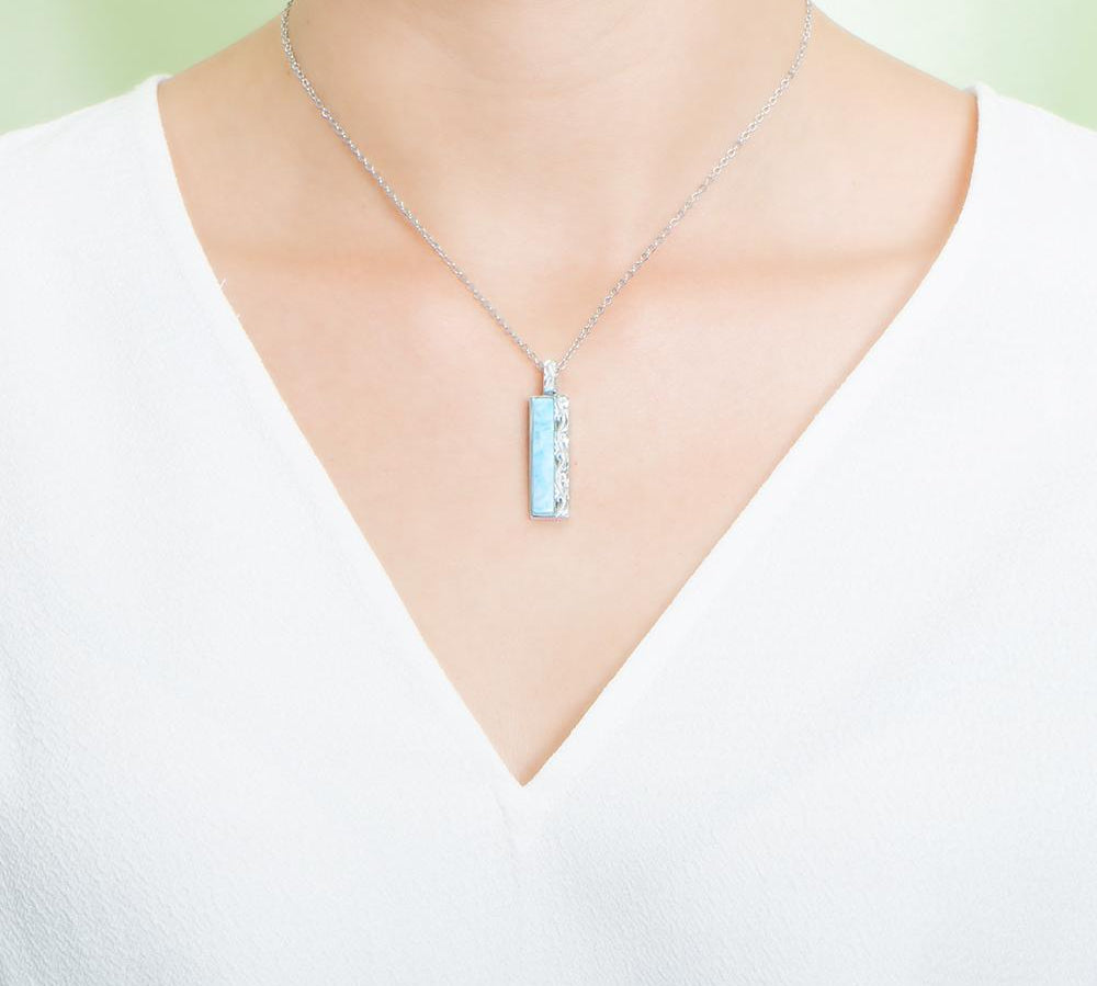 The picture shows a model wearing a 925 sterling silver larimar bar pendant.