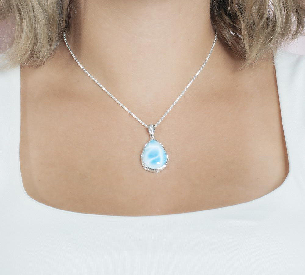 The picture shows a model wearing a 925 sterling silver larimar teardrop pendant.