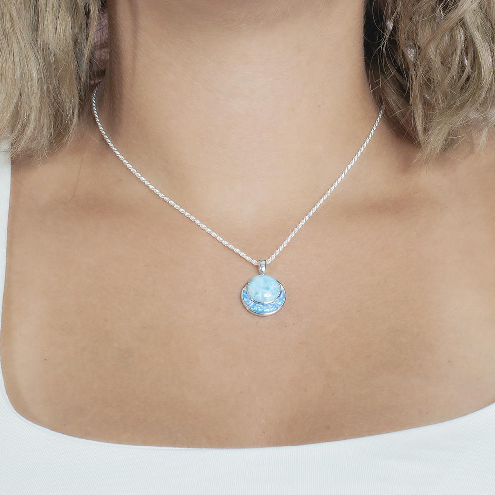 The picture shows a model wearing a 925 sterling silver larimar and opalite circle pendant.