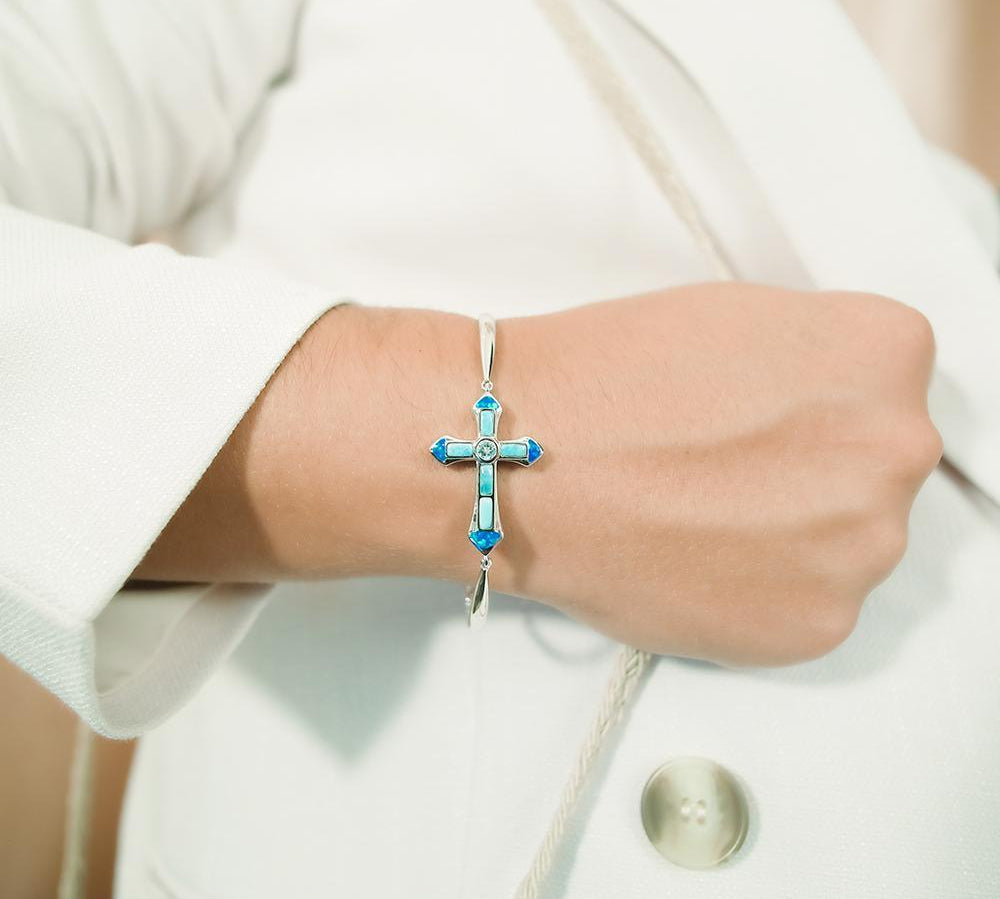 The picture shows a model wearing a 925 sterling silver larimar and opalite cross bracelet.