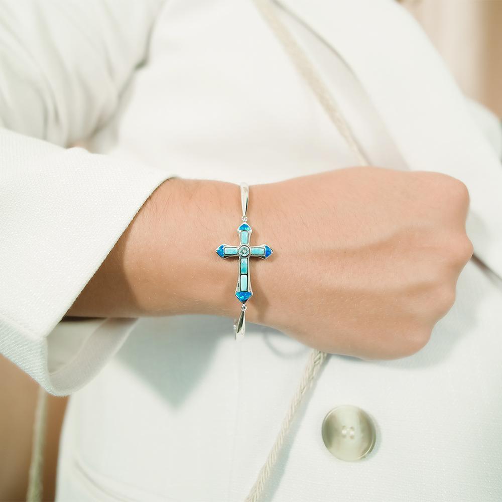 The picture shows a model wearing a 925 sterling silver larimar and opalite cross bracelet.