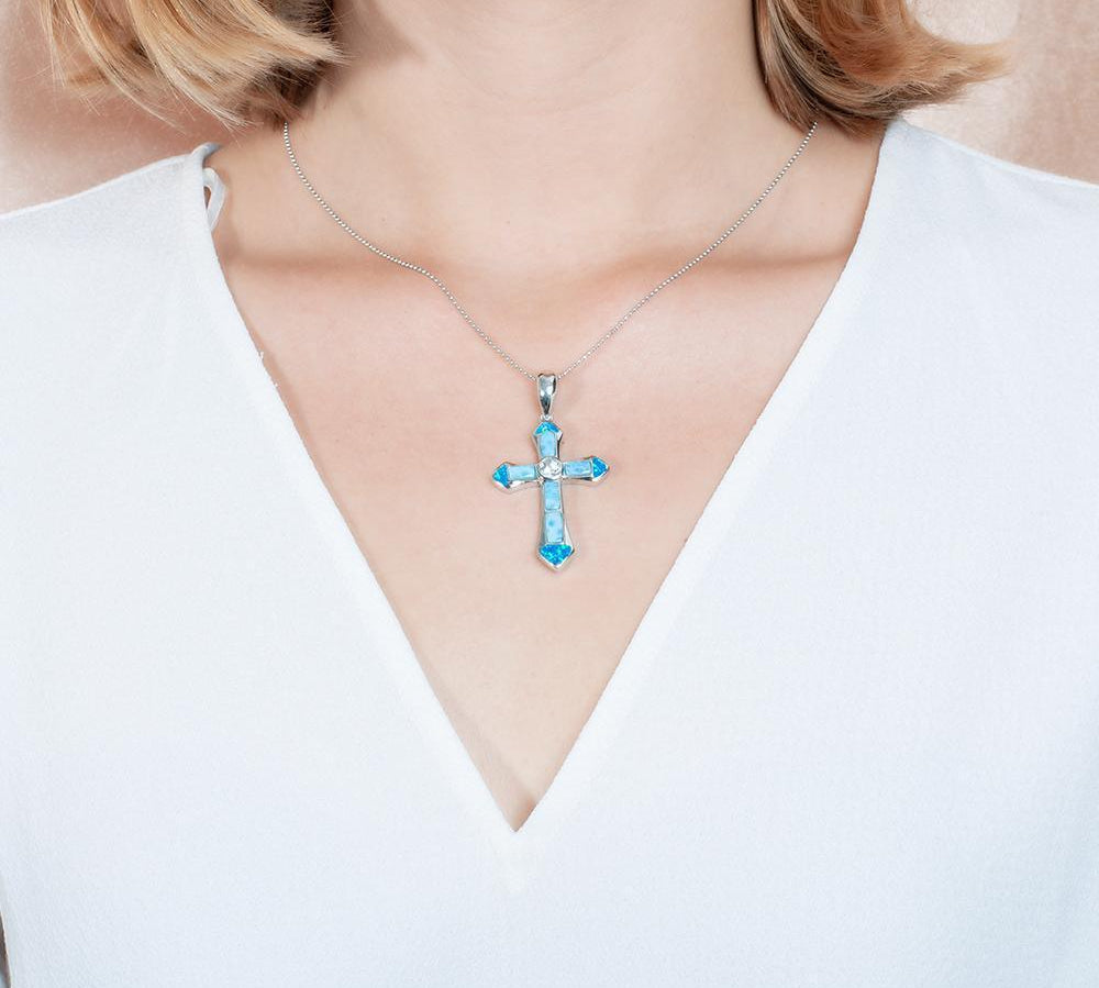 The picture shows a model wearing a 925 sterling silver larimar and opalite cross pendant.