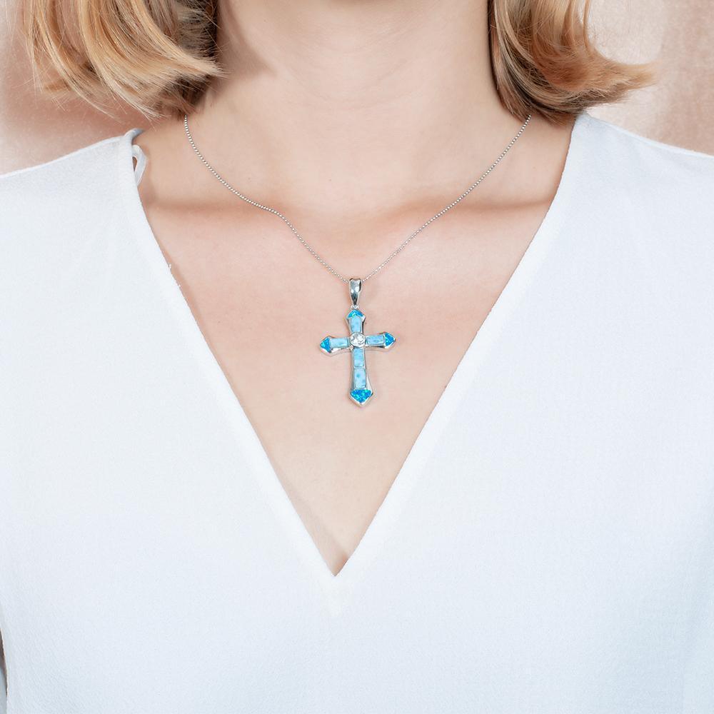 The picture shows a model wearing a 925 sterling silver larimar and opalite cross pendant.