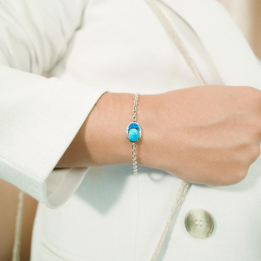 The picture shows a model wearing a 925 sterling silver larimar and opalite oval bracelet.