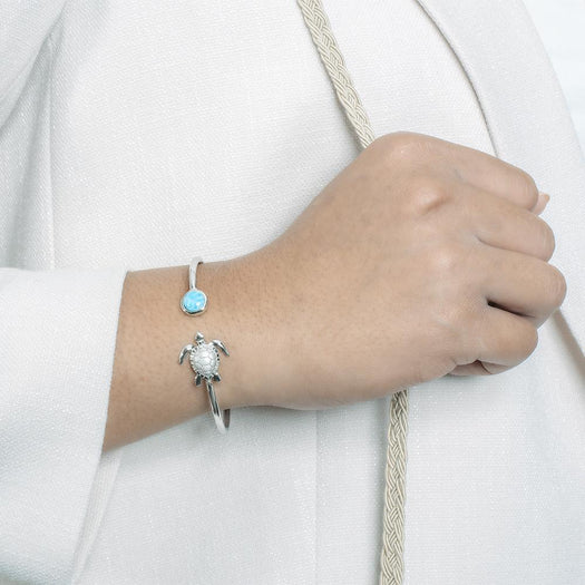 The picture shows a model wearing a 925 sterling silver larimar sea turtle bangle.