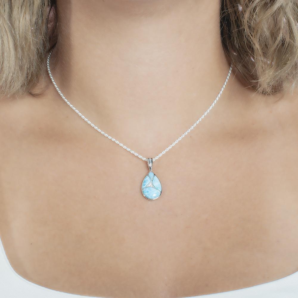 The picture shows a model wearing a 925 sterling silver larimar pieces of love teardrop pendant with cubic zirconia.