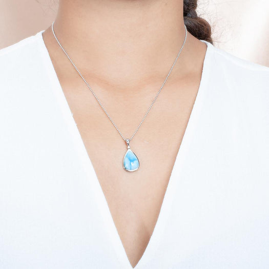 The picture shows a model wearing a 925 sterling silver larimar reuleaux teardrop pendant cubic zirconia.