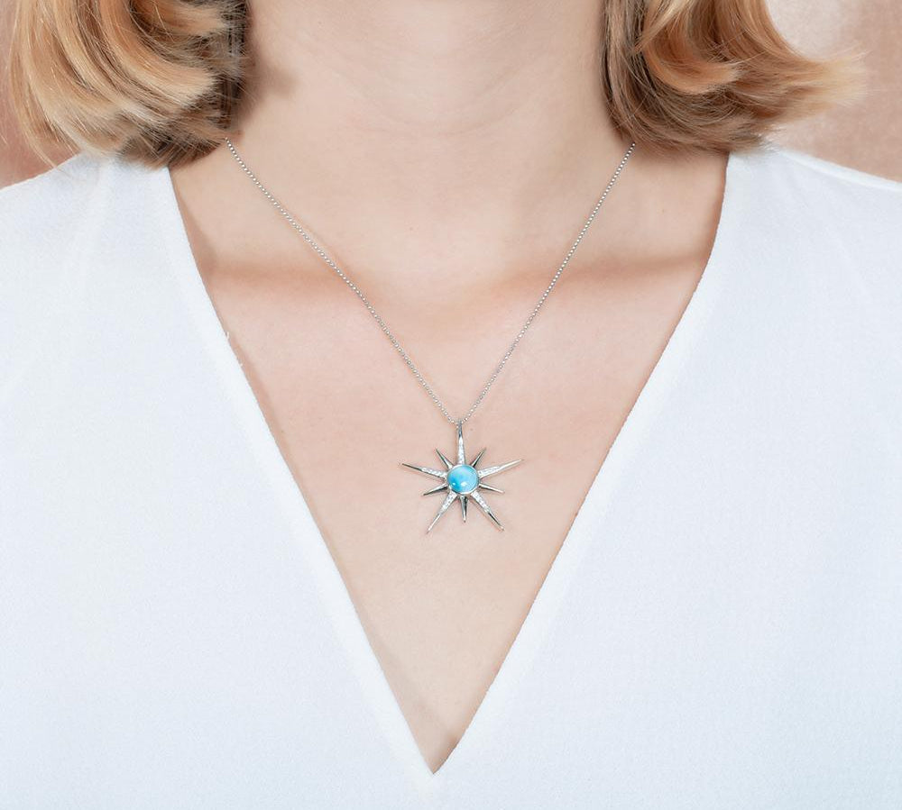 The picture shows a model wearing a 925 sterling silver larimar shooting star pendant.