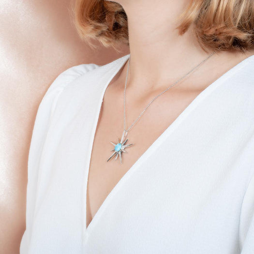 The picture shows a model wearing a 925 sterling silver larimar shooting star pendant.