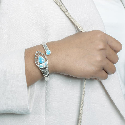 The picture shows a model wearing a 925 sterling silver larimar shrine bangle with topaz.