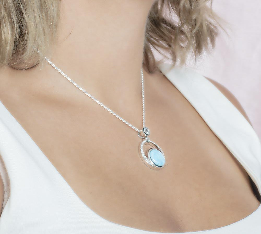 The picture shows a model wearing a 925 sterling silver larimar solar pendant.