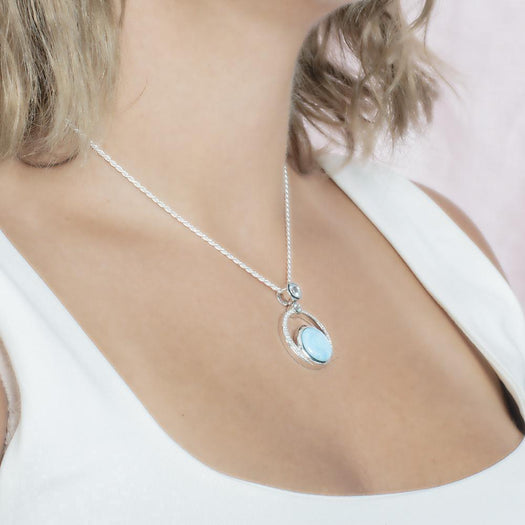 The picture shows a model wearing a 925 sterling silver larimar solar pendant.