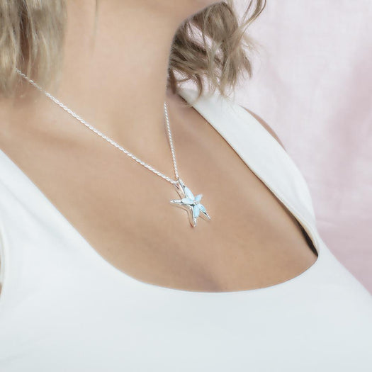 The picture shows a model wearing a 925 sterling silver larimar sea star pendant with topaz.