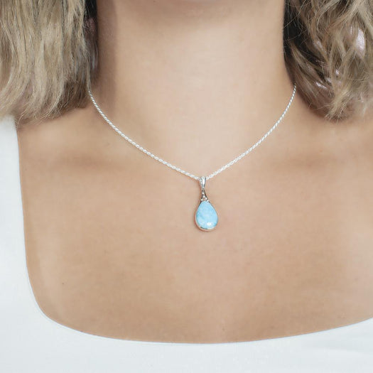 The picture shows a model wearing a 925 sterling silver larimar starry sky teardrop pendant with cubic zirconia.