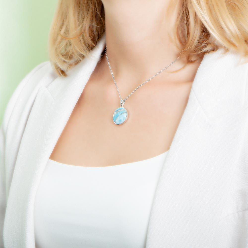 The picture shows a model wearing a 925 sterling silver larimar striped circle pendant with topaz.