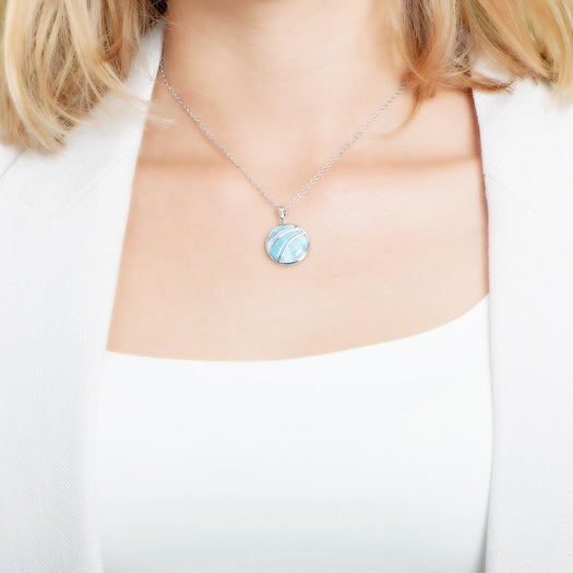 The picture shows a model wearing a 925 sterling silver larimar striped circle pendant with topaz.