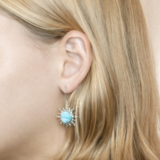 In this photo there is a model wearing a 925 sterling silver sun hook earring with a blue larimar gemstone.