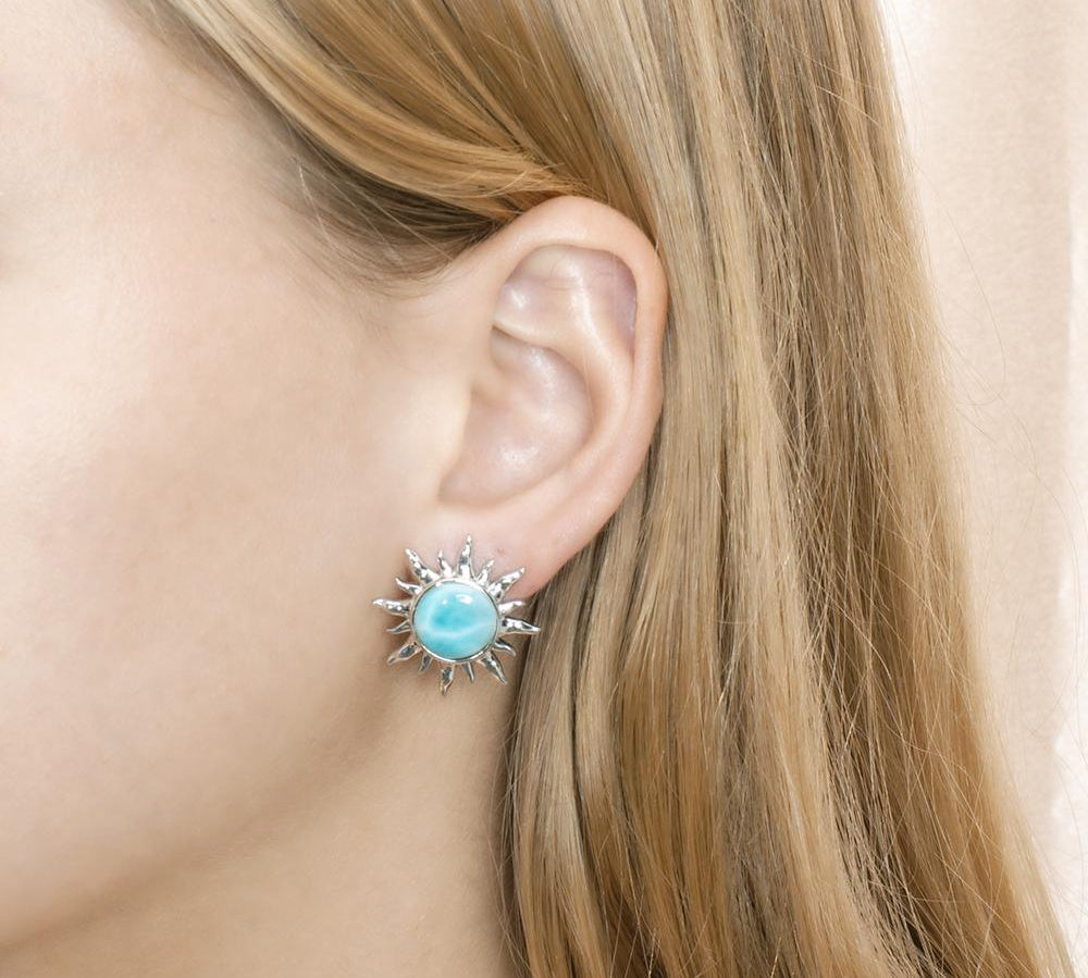 In this photo there is a model wearing a 925 sterling silver sun stud earring with a blue larimar gemstone